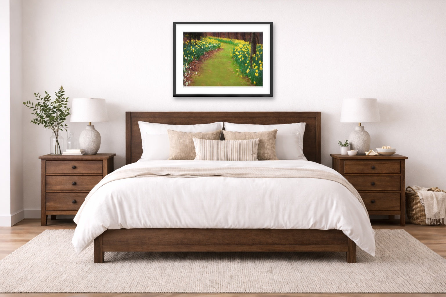 A bedroom with a wooden bed, white bedding, and a black framed artwork on the wall.