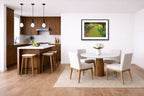 Modern kitchen and dining area with wooden floor, white walls, and a black framed picture on the wall.