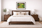 Espresso framed wall art hanging in a Bedroom with a wooden bed, white bedding, and framed artwork on the wall.