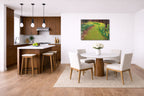 Modern kitchen and dining area with wooden floor, white walls, and a metal painting of a garden.
