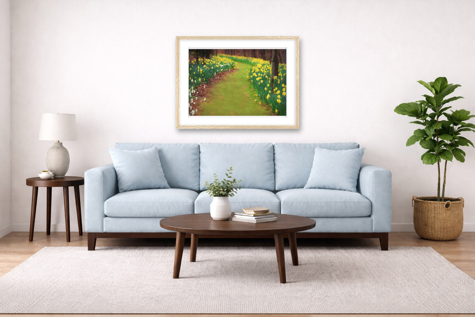 Oak framed wall art hanging in a lLiving room with a light blue sofa in a living room with a painting, a table, and plant.