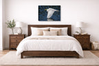 White Egret in Flight printed on canvas wall art displayed on a wall above a bed.
