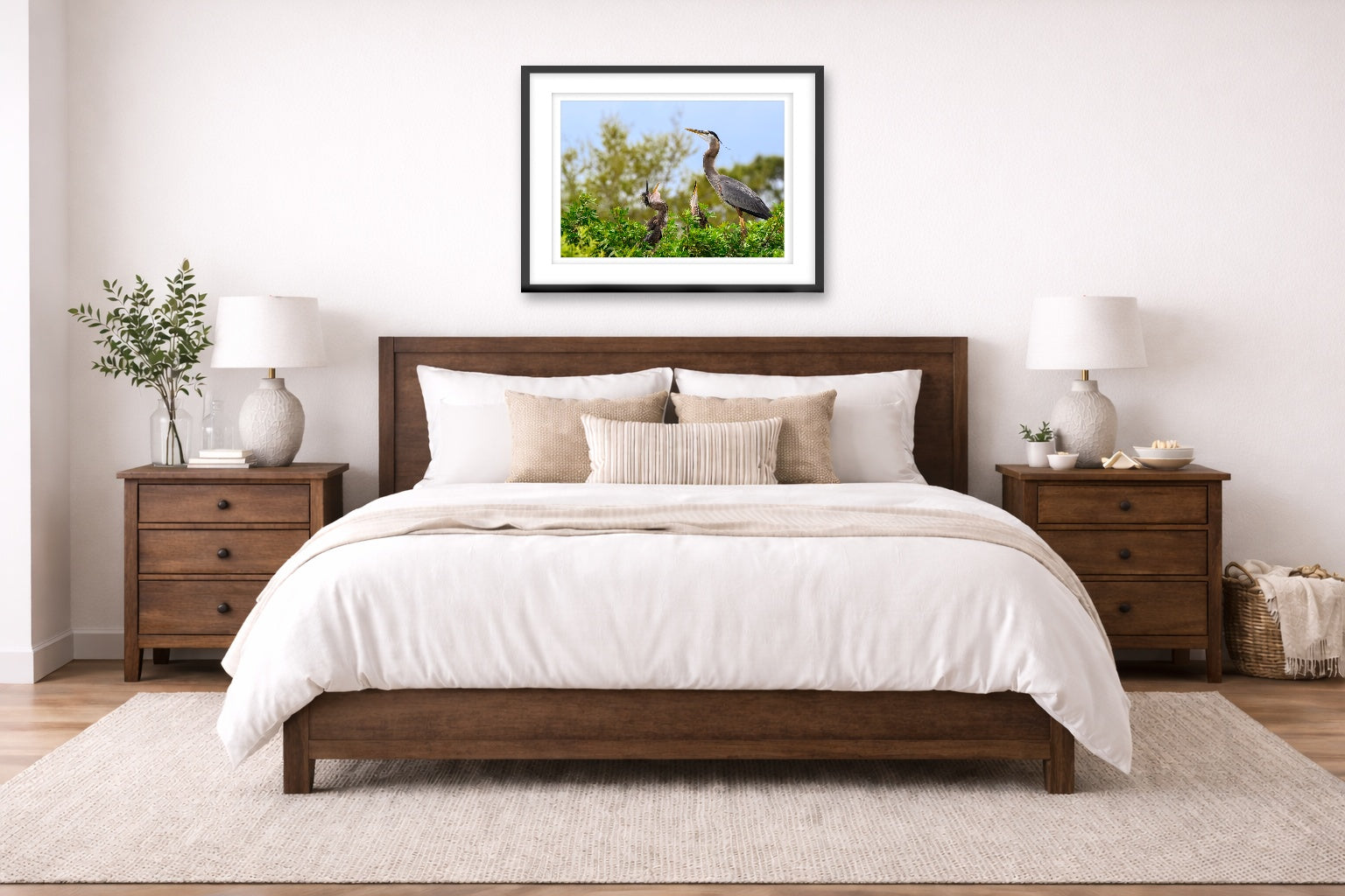 Blue Herons with Chicks printed on fine art paper, framed on a black frame and matted and hung on a wall on an bedroom wall.