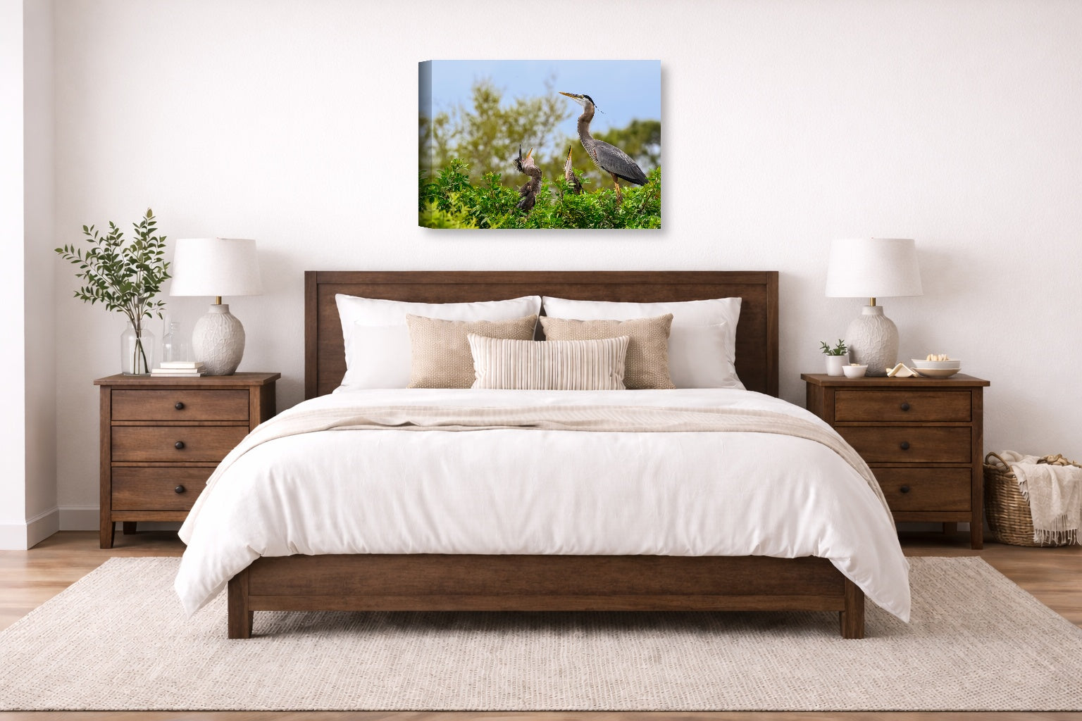 Blue Herons with Chicks printed on canvas wall art displayed on a wall above a bed.