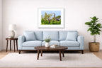 Blue Herons with Chicks printed on fine art paper, framed on a white frame and matted. Hung on a living room wall.