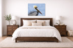 Pelican Posing against a blue sky printed on aluminum metal with wall anchors. Hung on a bedroom wall.