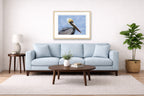 Pelican Posing against a blue sky printed on fine art paper, framed on a oak frame and matted. Hung on a living room wall.