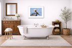 Pelican Posing against a blue sky printed on fine art paper, framed on a white frame and matted. Hung on a bathroom wall