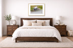 Blue Heron in Flight printed on fine art paper, framed in a oak frame and matted. Hung on a bedroom wall.