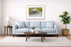 Blue Heron in Flight printed on fine art paper, framed on a oak frame and matted. Hung on a living room wall.