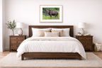 Moose in the Rockies printed on fine art paper, framed in a oak frame and matted. Hung on a bedroom wall.