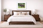 Moose in the Rockies printed on fine art paper, framed on a white frame and matted. Hung on a bedroom room wall