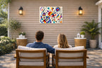 Geometric Abstract Musical Painting printed on water resistant canvas and mounted on a waterproof frame. Hung on a patio wall with couple.