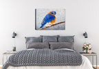 Painting of a bluebird on a branch by Carol Decker, printed on a canvas wrap hanging on a wall in the bedroom.