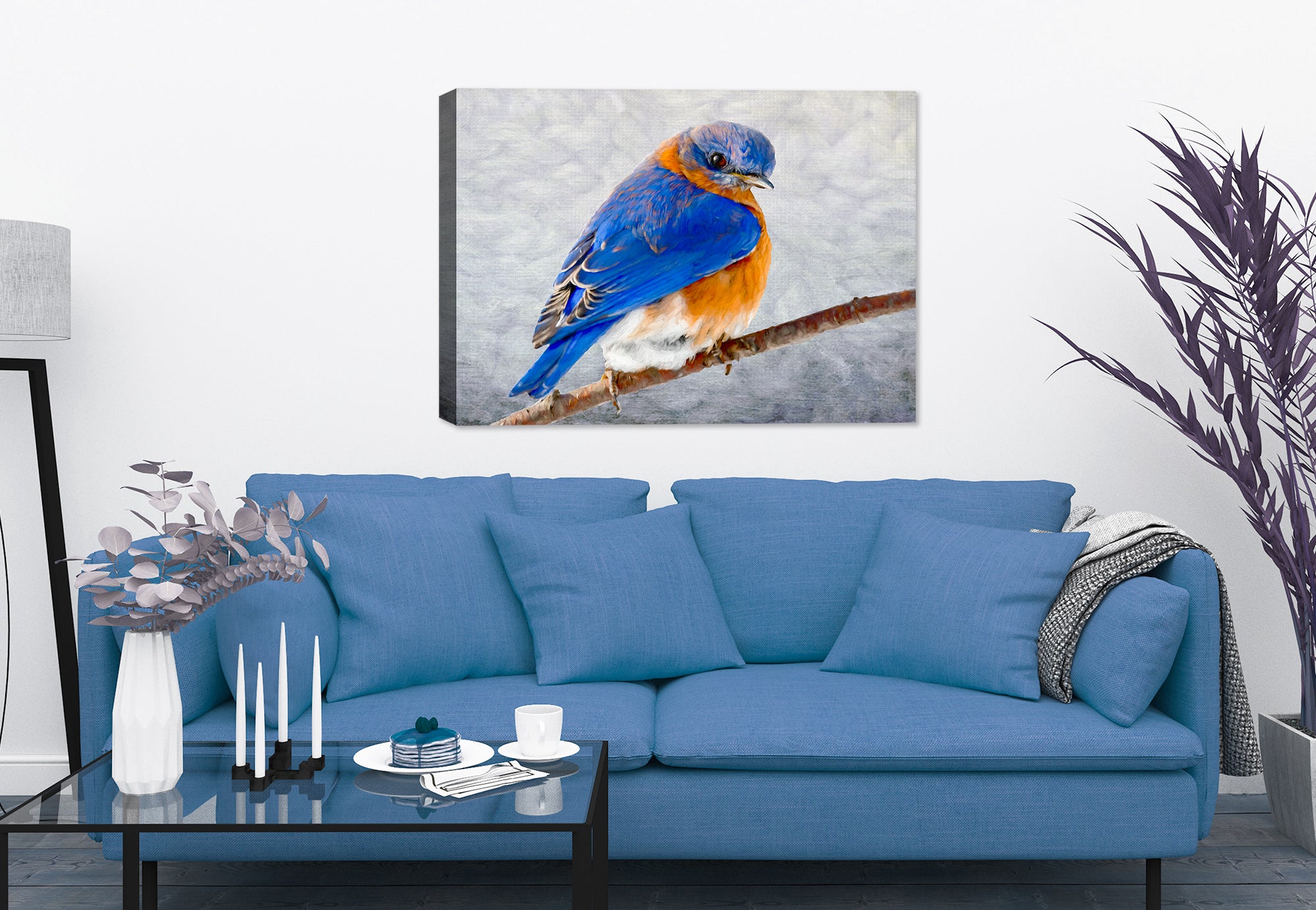 Painting of a bluebird on a branch by Carol Decker, printed on a canvas wrap hanging on a wall in the living room.