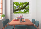 Photograph of a Blue Jay bird on a branch printed on a canvas wrap hanging on a wall in the dining room.