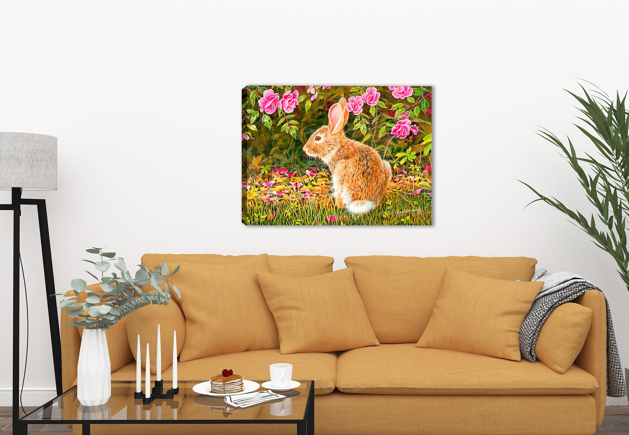 Image of a painting of a rabbit on a Bed of Roses on a canvas wrap hanging on the wall of a living room with a beige sofa 